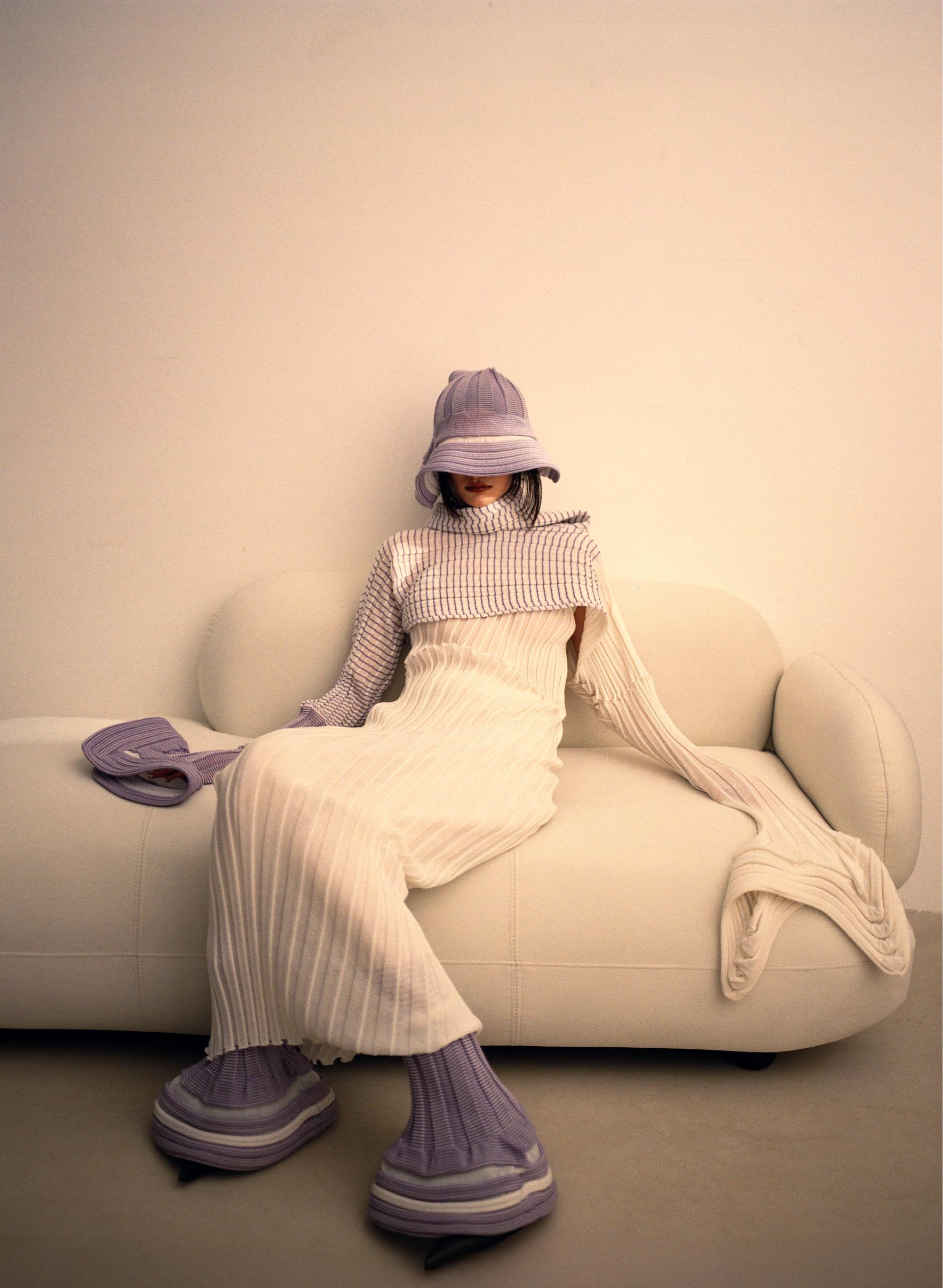 Purple and white cardigan, dress and pants _ Issey Miyake; Earring and bracelet _ Swarovski; Boots _ McQueen