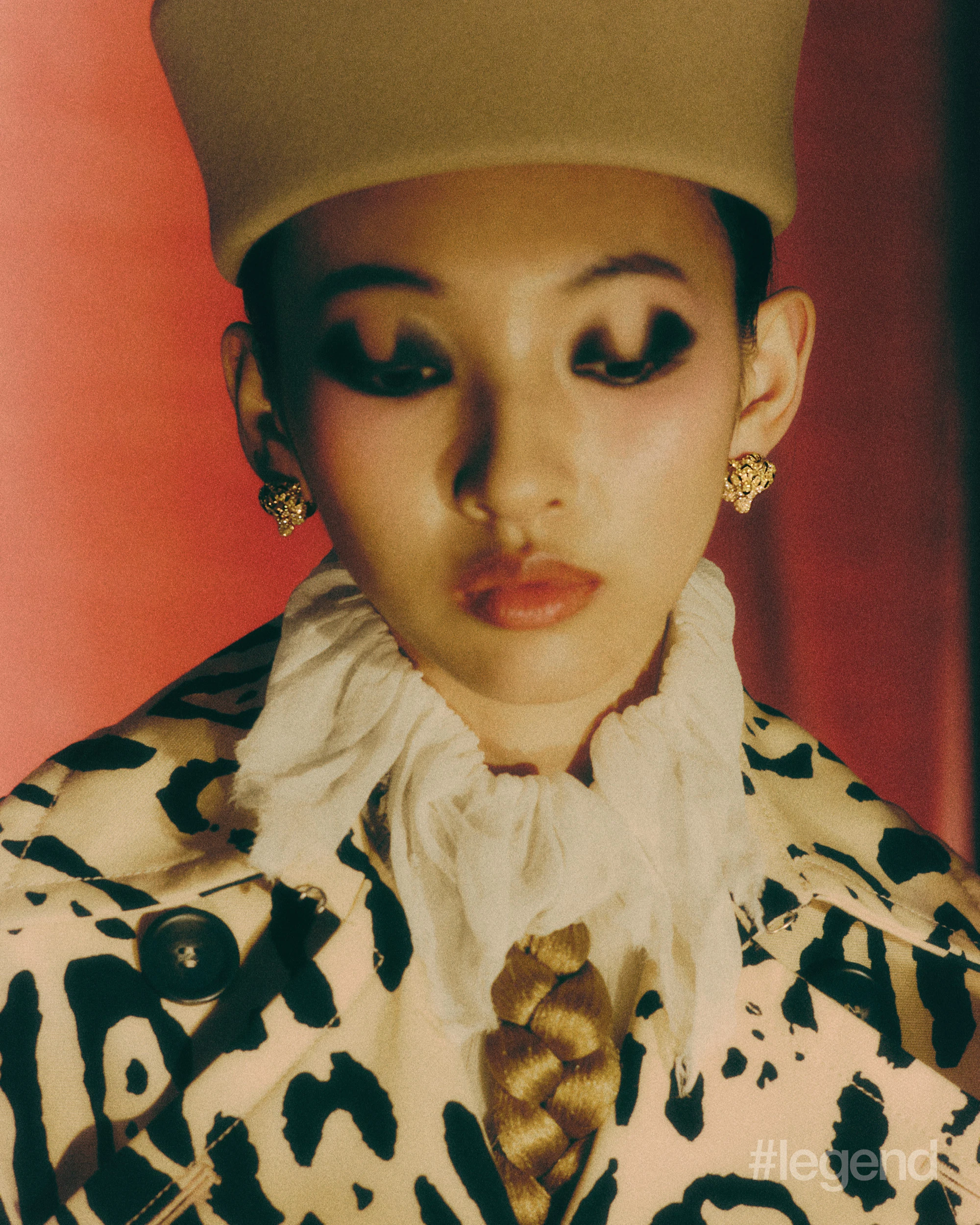 Panthère de Cartier earrings and ring _ Cartier; Ivory fringed collar blouse _ McQueen; Beige animal-print trench coat _ Sportmax; Beige rabbit fur hat _ Loro Piana (Stylist’s own corset).