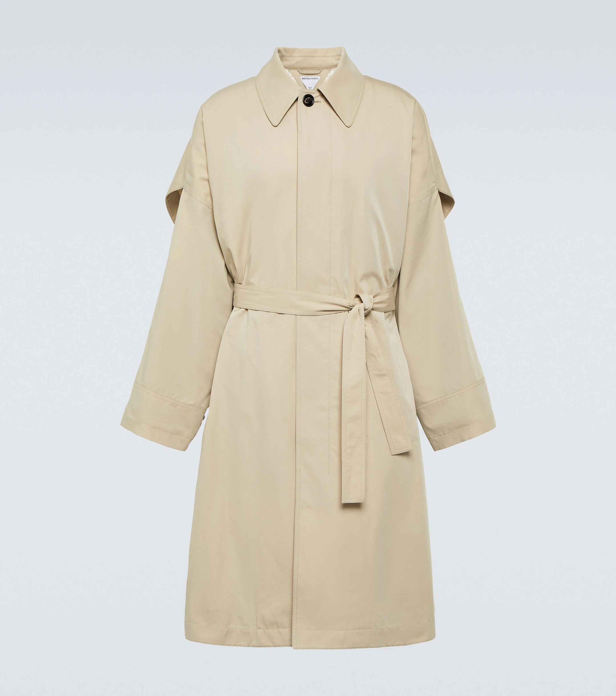 Beige cotton and silk cape trench coat _ Bottega Veneta; Black pleated cape coat _ Homme Plissé Issey Miyake from Harrods; White T-shirt _ The Row from Mr Porter; Cuffed denim jeans _ Jacquemus; Black suede and canvas sneakers _ Hermès