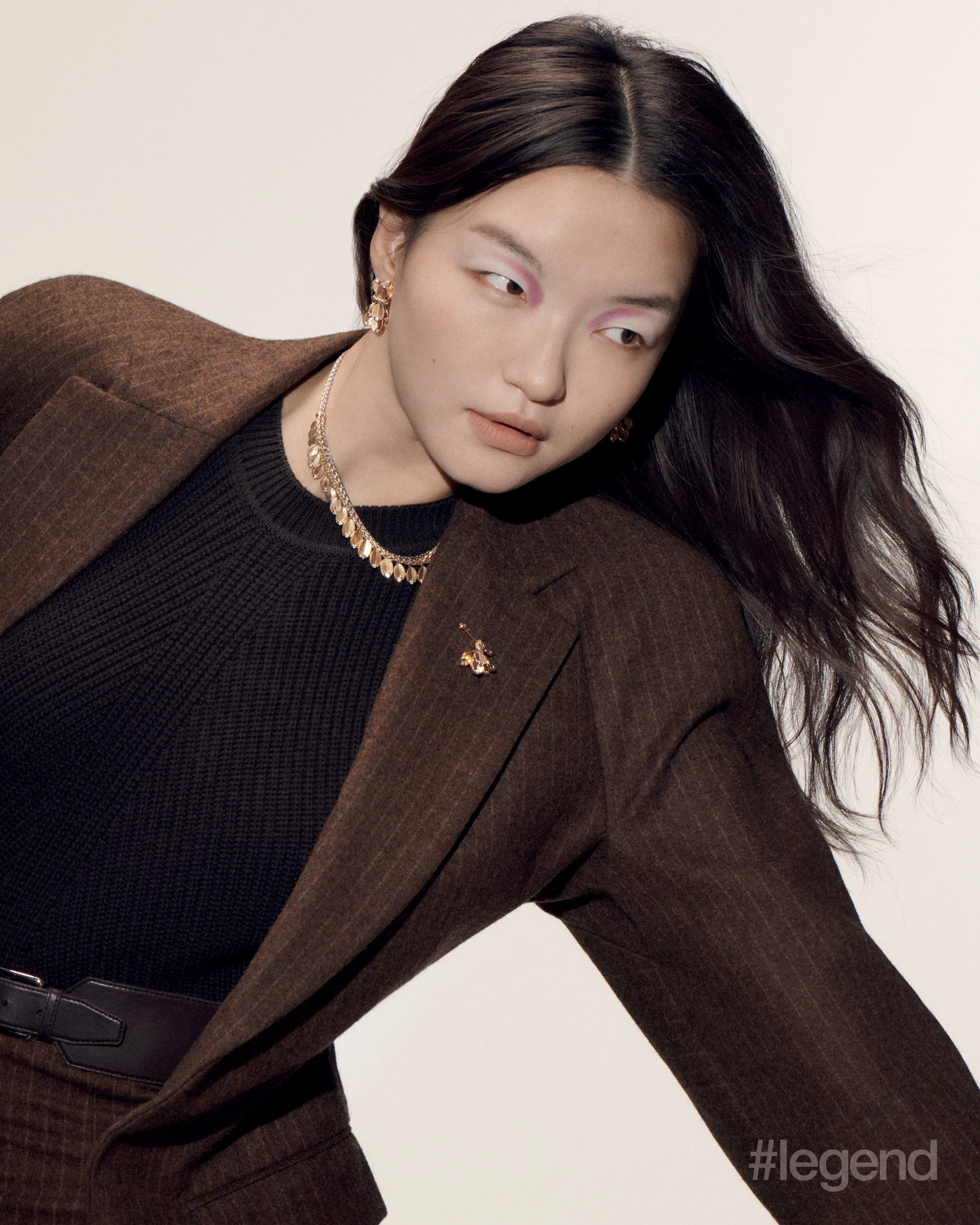 Grain de Café earrings in yellow and white gold with diamonds, necklace in yellow gold with diamonds, and brooch in yellow and white gold _ Cartier; Brown jacket and skirt, and black jumper _ Hermès