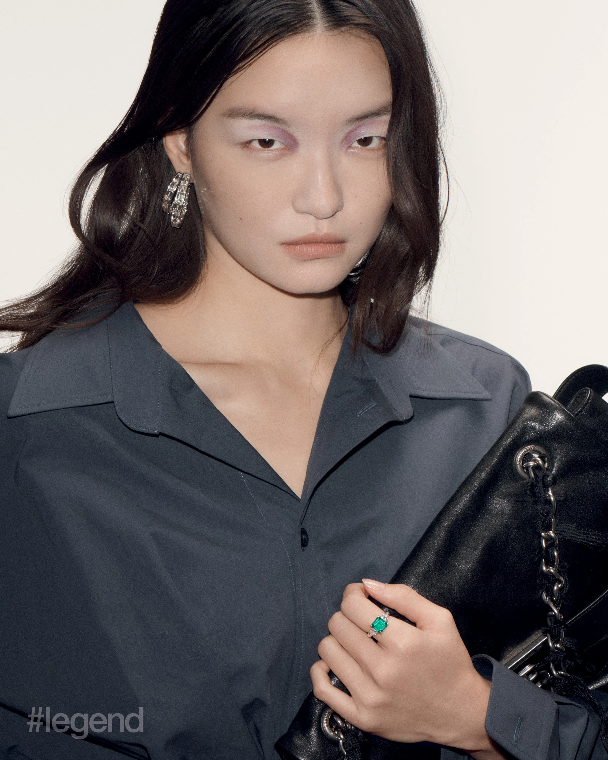 High Jewellery double hoop earrings in white gold with diamonds, and ring in platinum with Colombian emerald and diamonds _ Moussaieff; Grey dress and black bag _ Balenciaga