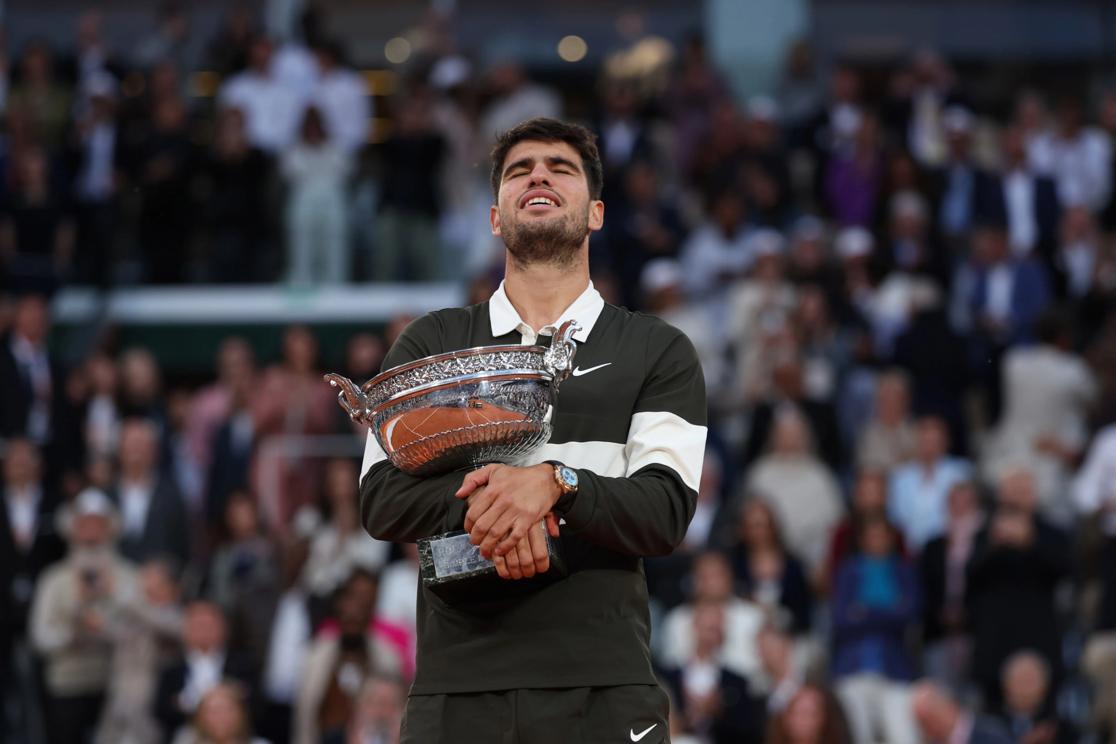 Carlos Alcaraz hugs his French Open trophy.