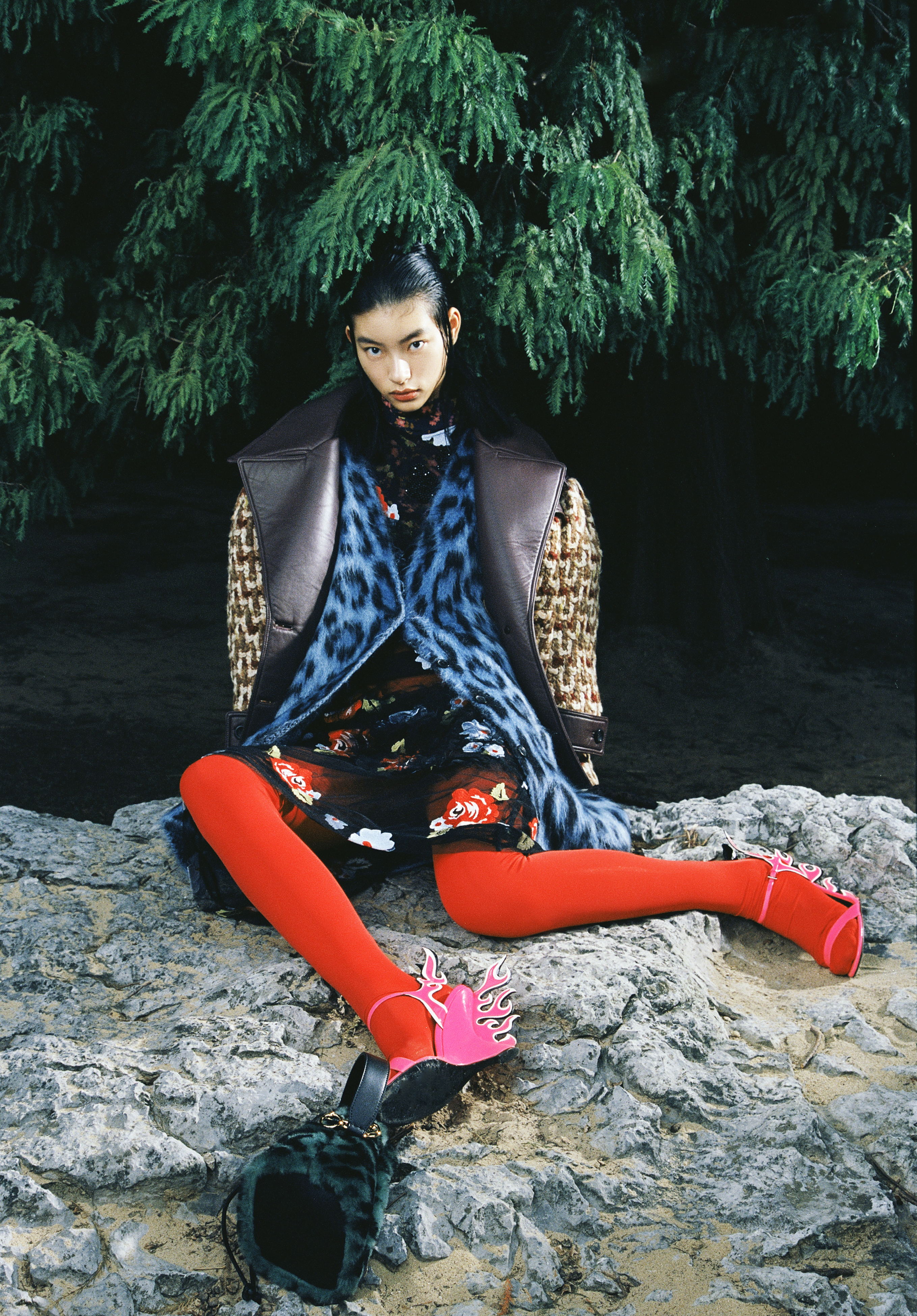 Black leather and beige tweed jacket by Miu Miu; Blue leopard-print cardigan by Loewe; Black floral tulle dress by Simone Rocha; Red leggings by Idism; Pink flame wedges by Prada; Green furry bag by Fendi