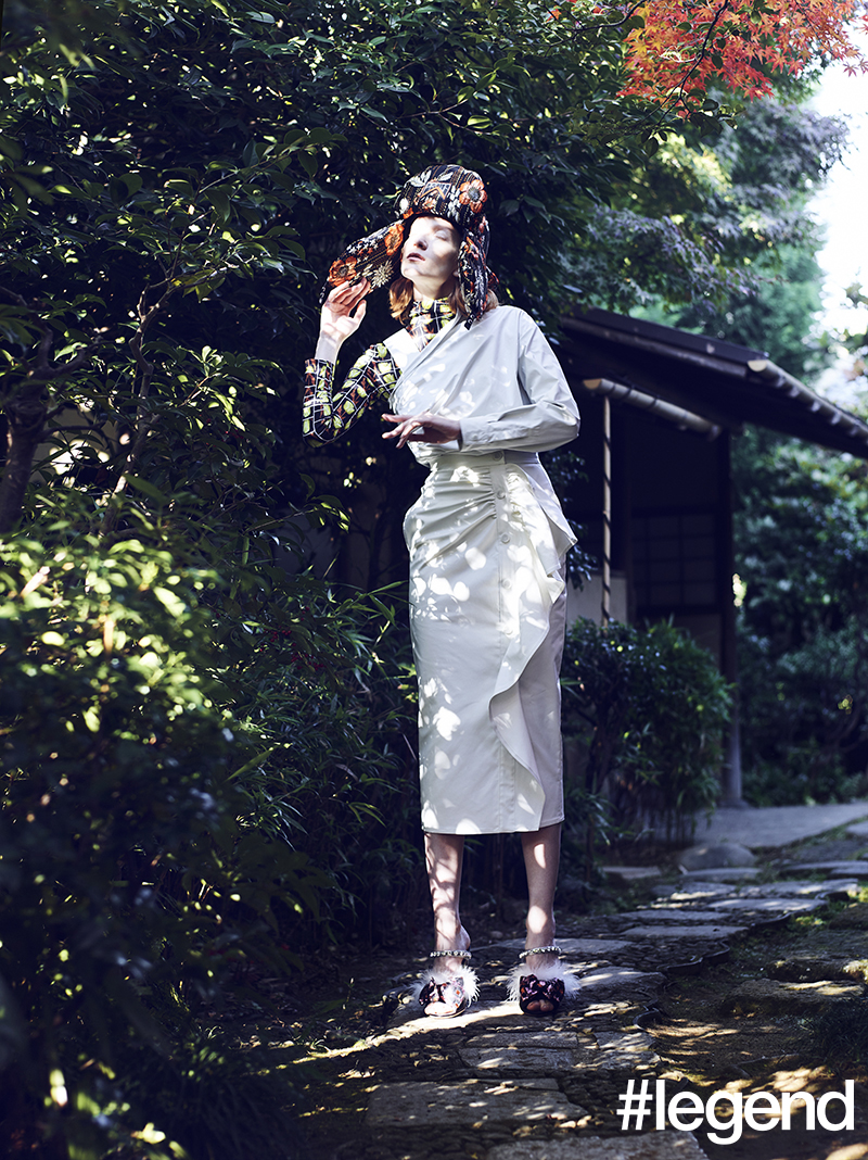 Orange and black floral brocade padded hat and green and black printed top _ Prada, White laminated fabric off-shoulder top, gathered skirt and leather belt (worn on shoulder) _ Max Mara, Pink and black metallic brocade mules with feathers and crystals _ Miu Miu