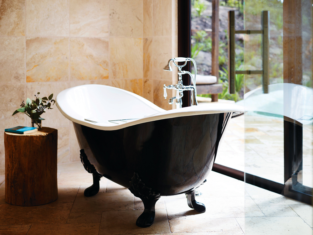 Luxuriously appointed bathrooms have sliding doors that open out to the hillside