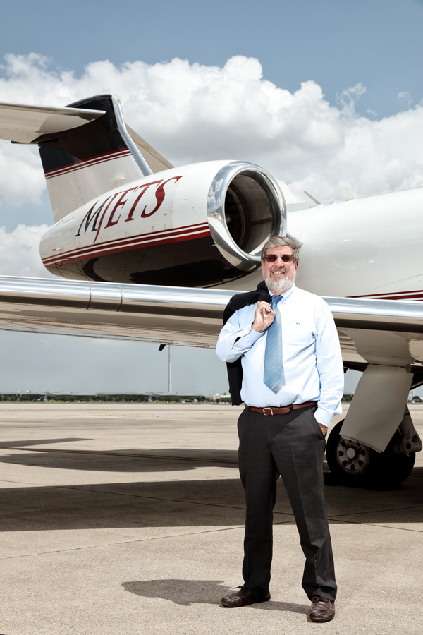 William Heinecke standing in front of an aircraft from his MJets company