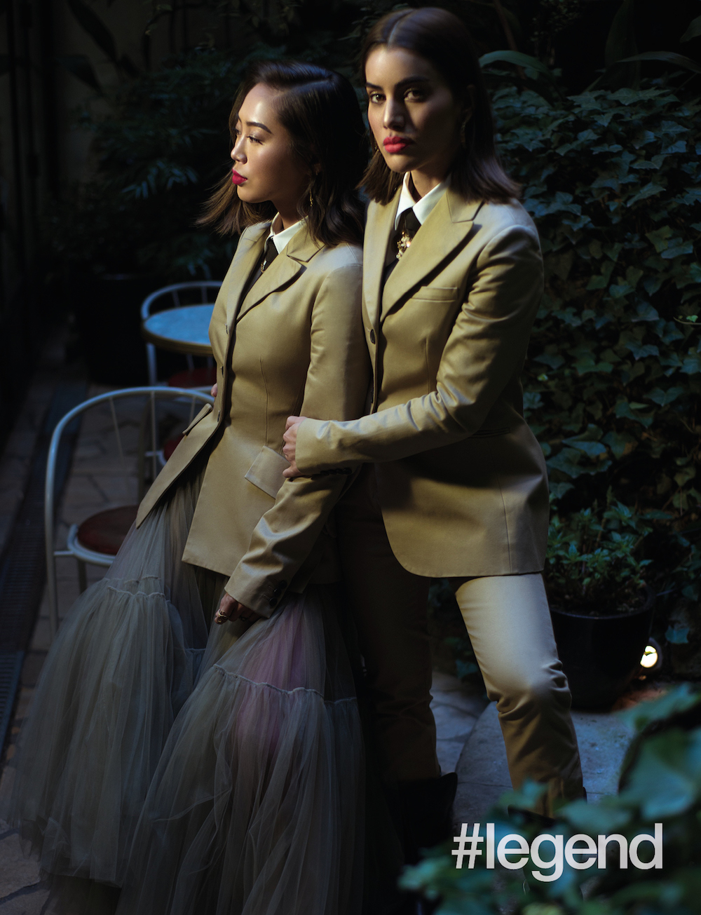 On Aimee:  Beige cotton jacket, white cotton button-down shirt, khaki tulle skirt, black silk tie, earrings, rings and necklace by Dior; (Pink tights stylist’s own); Make-Up _ Rouge Dior Ultra Rouge #763  and Dior Backstage Glow Palette  On Camila:  Beige cotton jacket, white cotton button-down shirt, beige cotton trousers, black silk tie, earrings and Diorodeo horse choker by Dior;   Make-Up _ Rouge Dior Ultra Rouge #450 and Diorshow Bold Brow #002