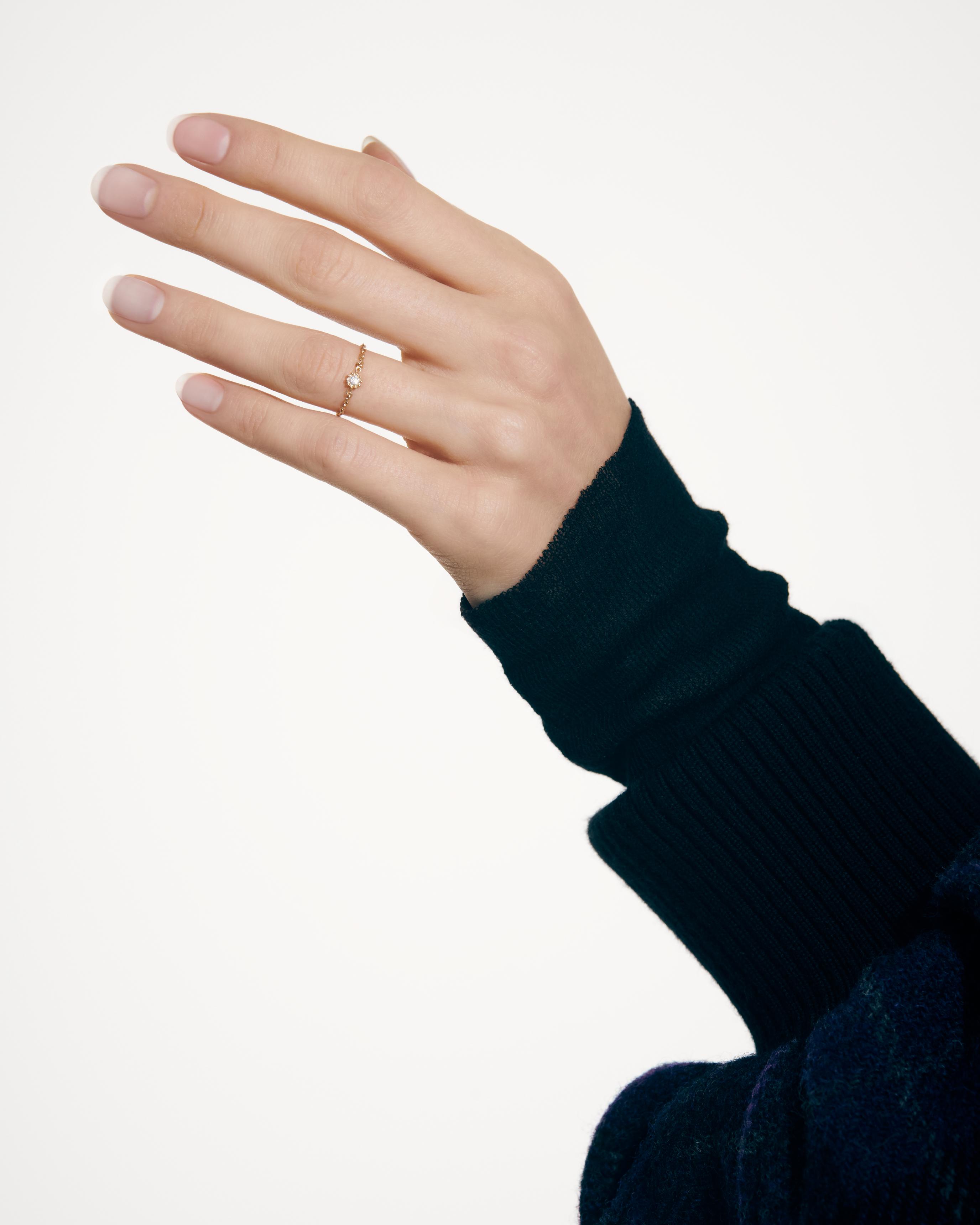 Joaillerie Mimirose ring in yellow gold with diamonds _ Dior; Blue cropped bomber jacket and black hoodie top _ Dior