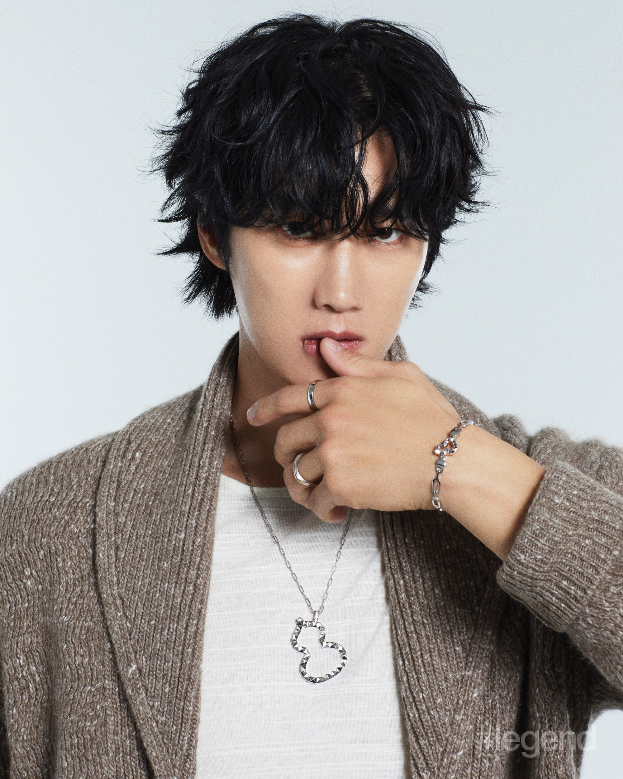 Wulu 18 maxi pendant in 18k white gold, chain in 18k white gold, Paperclip interchangeable bangle in 18k white gold, Tien Di ring in platinum and 18k rose gold, and Hong Xian ring in platinum and red HyCeram® _ Qeelin; Beige cardigan and white T-shirt _ Brioni