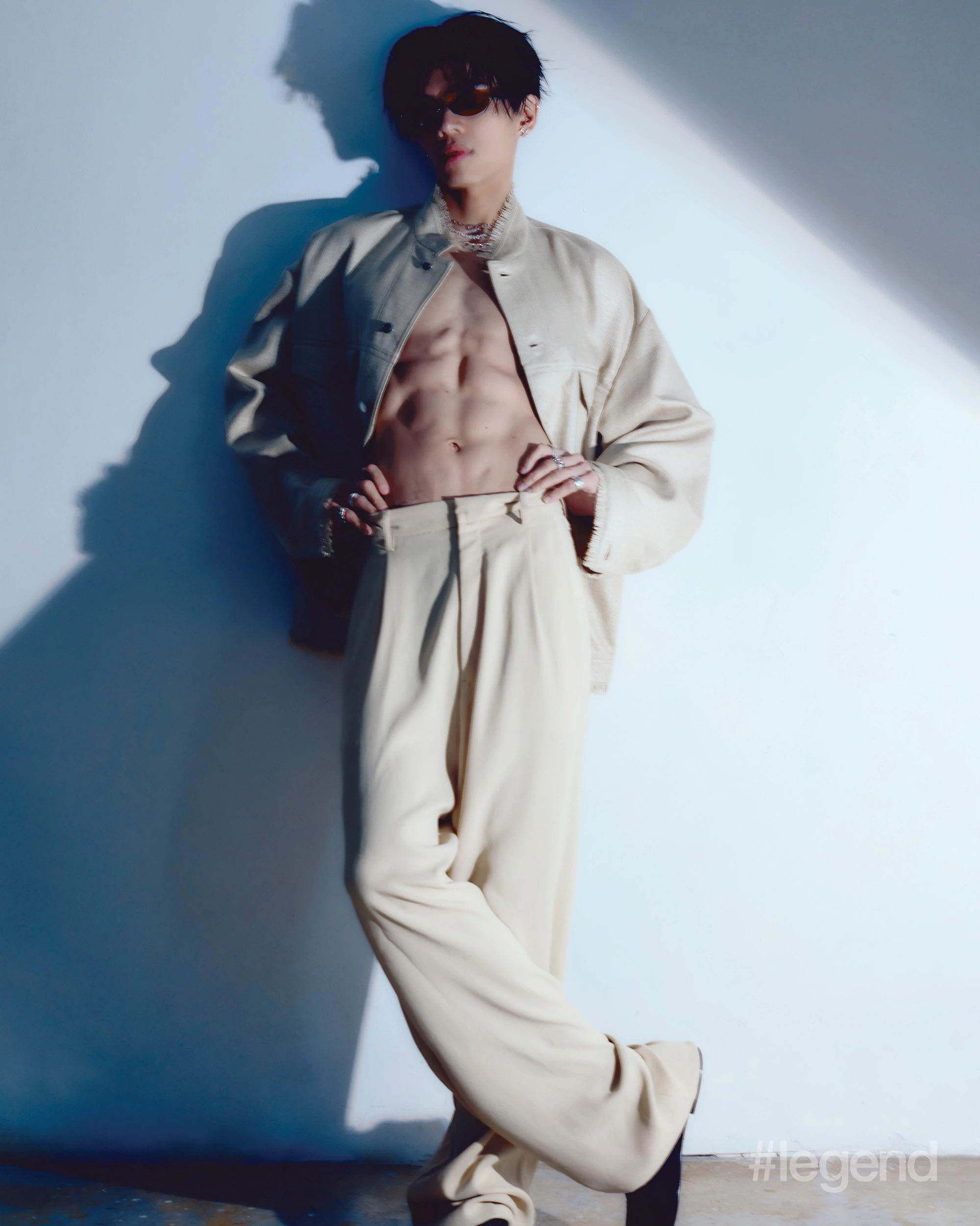 Beige waist jacket with front pocket details, beige wide leg trousers _ Emporio Armani; Black horn bio-based injected nylon, with mirror silver lenses sunglasses _ Balenciaga; Black calf leather moccasin boots _ Both; Silver cubic zirconia petals ornament earrings _ Midnightfactory.