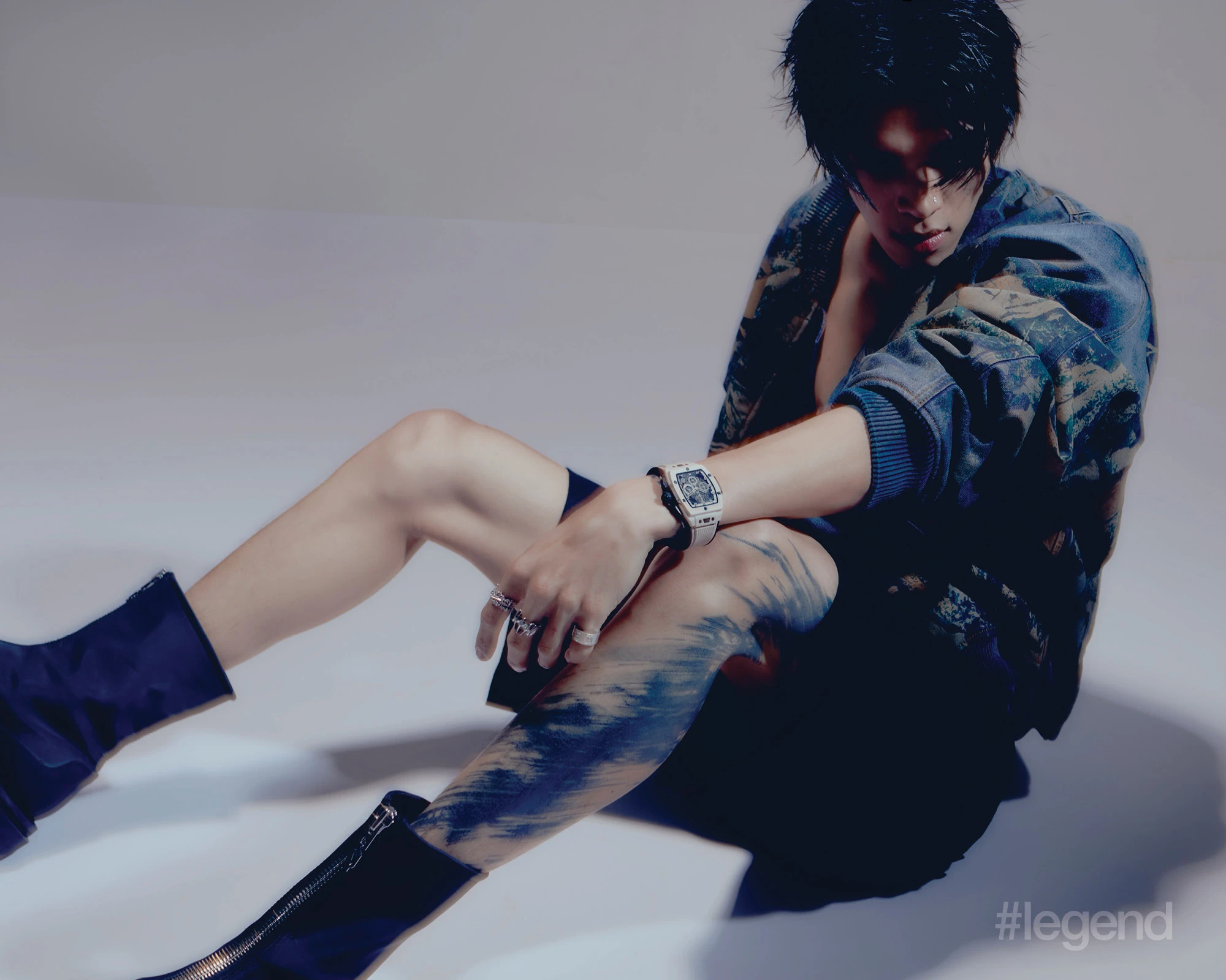 Blue padded printed recycled-denim bomber jacket _ Acne Studios; Black linen fabric shorts with pocket details _ Dolce & Gabbana; Black calf leather high boots with zip details _ Both.