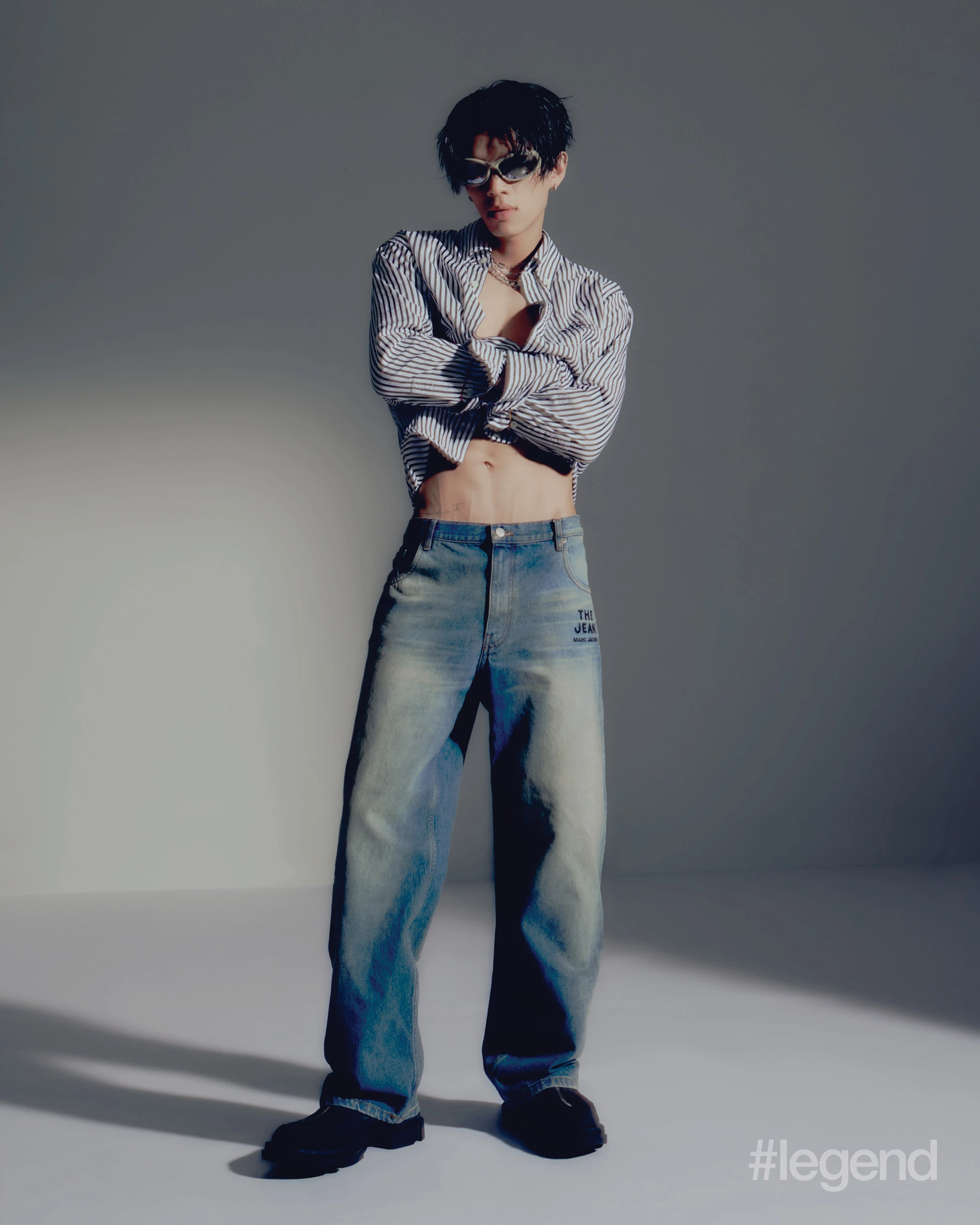 Black striped cotton front button shirt, navy washed straight leg jeans _ Marc Jacobs; Black calf leather moccasin boots _ Both; Ivory horn bio-based injected nylon, with mirror silver lenses sunglasses _ Balenciaga; Silver 925 sterling silver with rhodium-plating hexnut and gear earrings _ Midnightfactory.